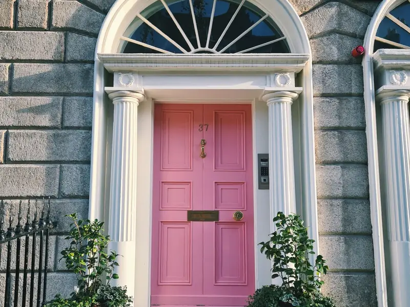 Pink door framed by stone pillars in Dublin, Ireland