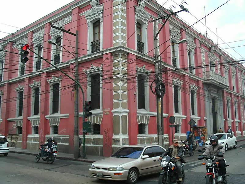 Red-pink corner building with white trim in Guatemala City